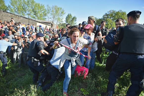TOVARNIK, CROATIA - SEPTEMBER 17: Migrants force their way through police lines at Tovarnik station to board a train bound for Zagreb on September 17, 2015 in Tovarnik, Croatia. Migrants are now diver ...