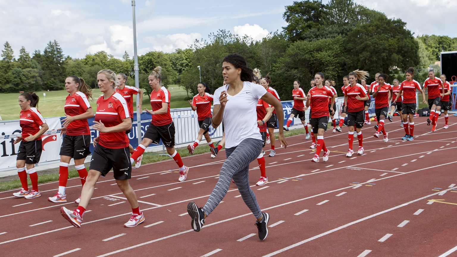 Switzerland&#039;s sprinter Mujinga Kambundji (white) leads Switzerland&#039;s players during a special training session, in Macolin, Switzerland, Monday, July 3, 2017. The Swiss national soccer team  ...