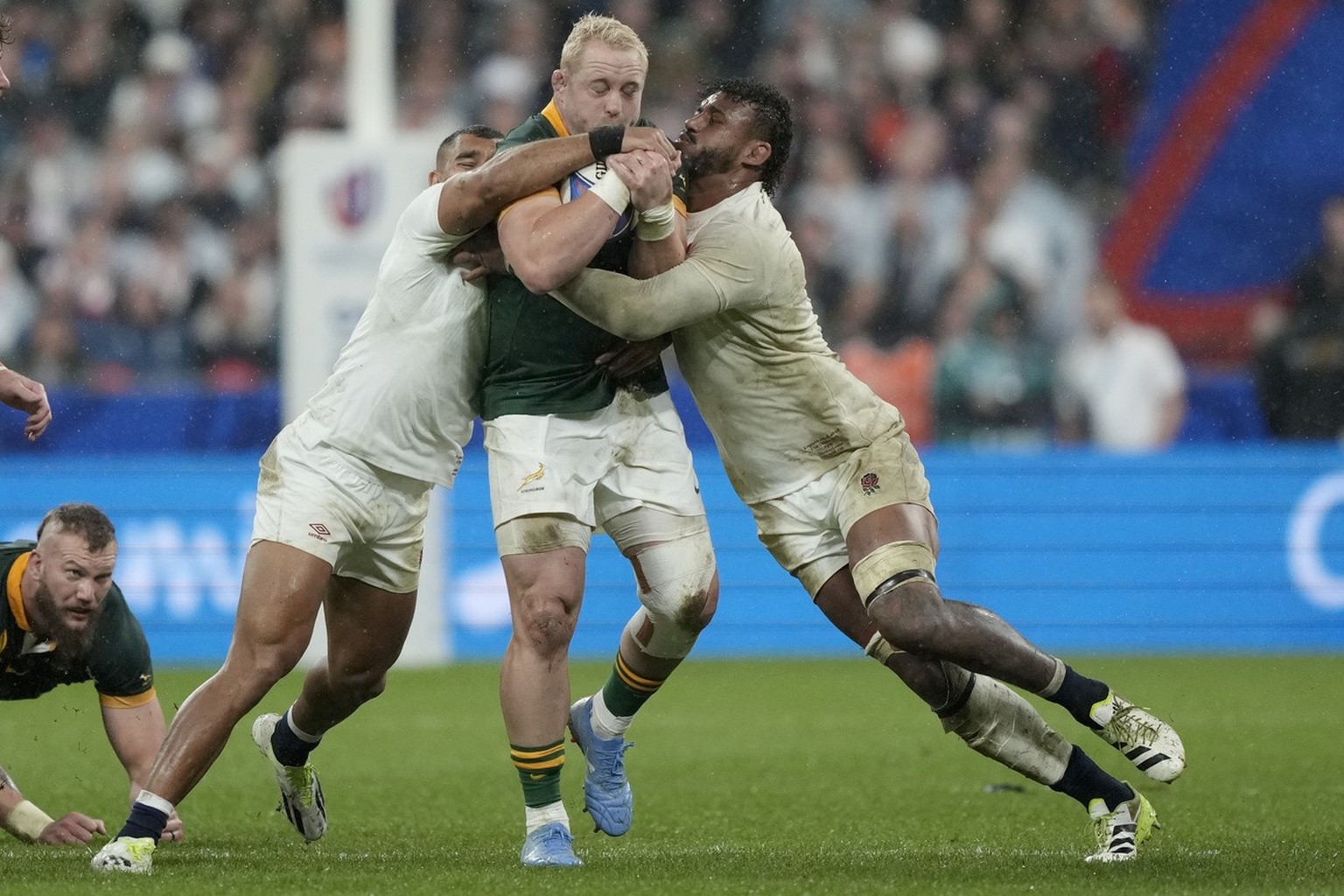 South Africa's Vincent Koch runs with the ball as England's Courtney Lawes and Joe Marchant attempt to stop him during the Rugby World Cup semifinal match between England and South Africa at ...