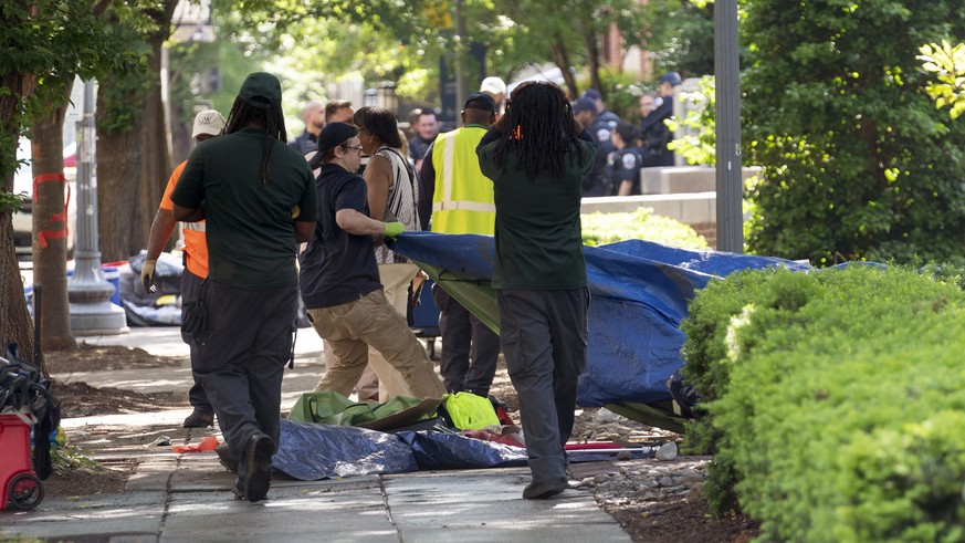 Workers carry student tents to a dump truck after police cleared a pro-Palestinian tent encampment at George Washington University early Wednesday and arrested demonstrators, Wednesday, May 8, 2024, i ...