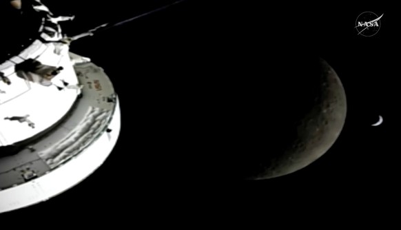 In this image from video provided by NASA, the Orion Spacecraft, the Earth and the Moon are seen from a camera as the Artemis II crew and spacecraft travel farther into Space, Monday, April 6, 2026. ( ...
