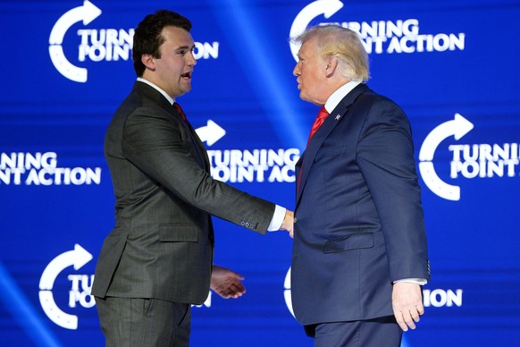 FILE - Former President Donald Trump, right, shakes hands with Turning Point CEO Charlie Kirk before speaking during the Turning Point USA Student Action Summit, July 23, 2022, in Tampa, Fla. (AP Phot ...