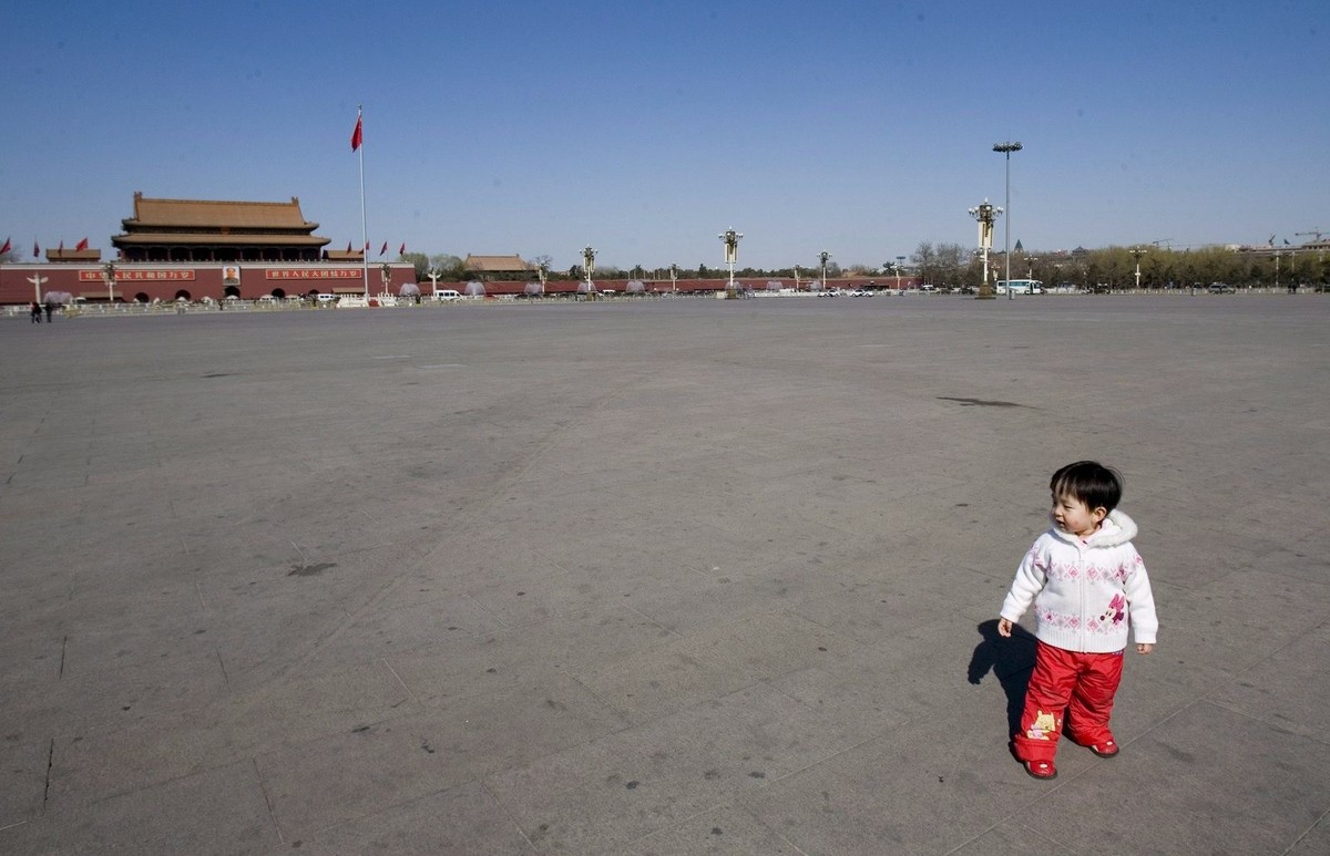 epa01283585 A child stands on a deserted Tiananmen Square during a session of the CPPCC going on inside the Great Hall of the People in Beijing, China, 13 March 2008. Family planning minister Zhang We ...