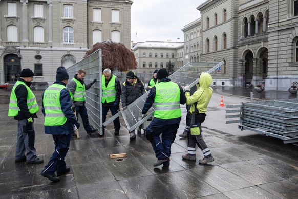 Polizisten und Logistikpersonal stellen einen Schutzzaun auf dem Bundesplatz auf, am Sonntag, 28. November 2021, in Bern. Erstmals wird an einem Abstimmungssonntag der Bundesplatz abgeriegelt. Die Geg ...