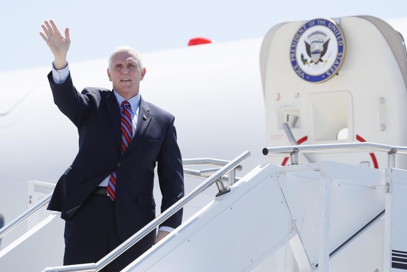 Vice President Mike Pence waves as he stops off Air Force Two after arriving at the Des Moines International Airport before meeting with faith leaders and food industry executives in response to the c ...