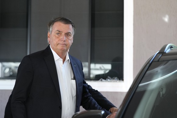 Former Brazilian President Jair Bolsonaro enters a car after speaking to the press outside his home after Federal Police agents carried out a search and seizure warrant in Brasilia, Brazil, Wednesday, ...