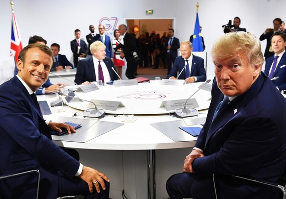 epa07792013 French President Emmanuel Macron (L) and US President Donald Trump (R) attend a G7 working session on &#039;International Economy and Trade, and International Security Agenda&#039; during  ...