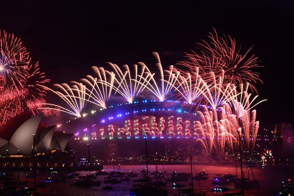 epa09661361 The midnight fireworks are seen over the Sydney Opera House and Sydney Harbour Bridge during New Year&#039;s Eve celebrations in Sydney, Australia, 01 January 2022. EPA/DEAN LEWINS AUSTRAL ...