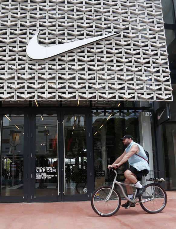 A cyclist rides past the Nike Miami store on the Lincoln Road Mall, Tuesday, Sept. 4, 2018, in Miami Beach, Fla. Nike&#039;s stock was falling in early trading on Tuesday following an announcement tha ...