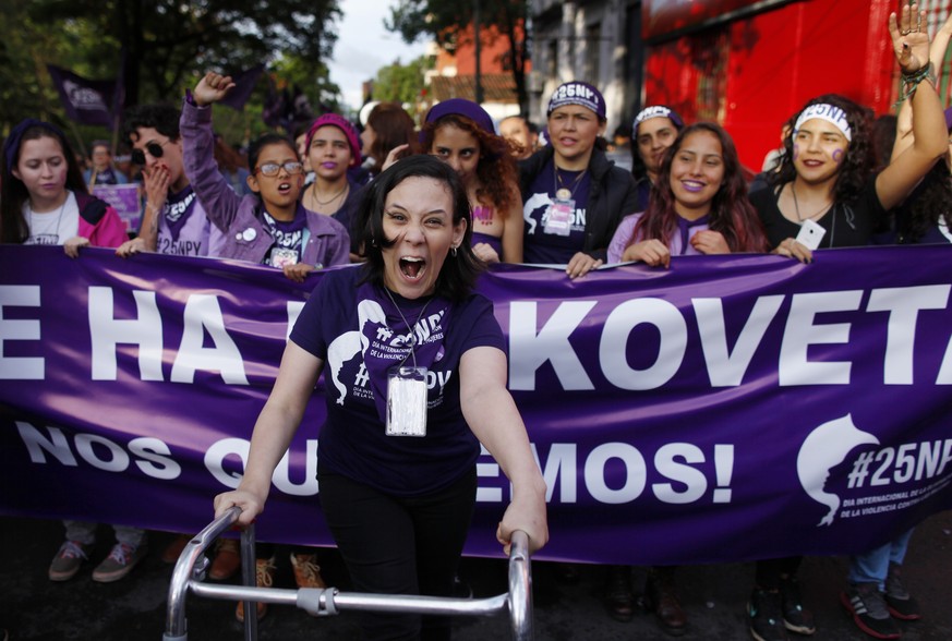 A woman using a walker leads a march marking the International Day for the Elimination of Violence against Women, in Asuncion, Paraguay, Saturday, Nov. 25, 2017. According to officials there is at lea ...