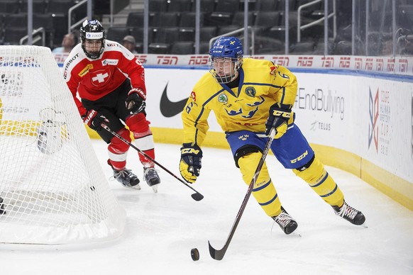 Sweden's Victor Soderstrom (6) is pursued by Switzerland's Lionel Marchand (9) during first period of a Hlinka Gretzky Cup hockey game in Edmonton, Alberta, Tuesday, Aug. 7, 2018. (Codie McL ...