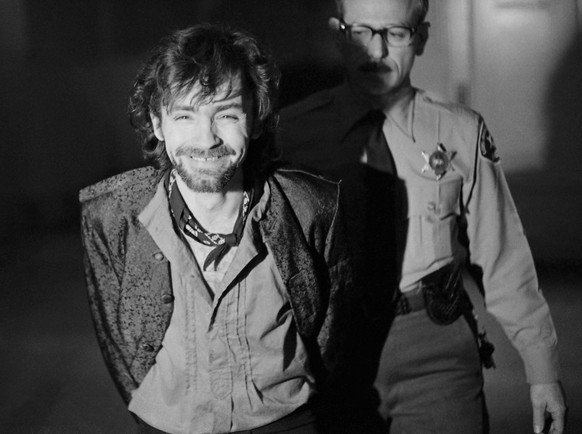 FILE - In this Dec. 21, 1970 file photo, a smiling Charles Manson goes to lunch after an outbreak in court that resulted in his ejection, along with three women co-defendants, from the his murder tria ...