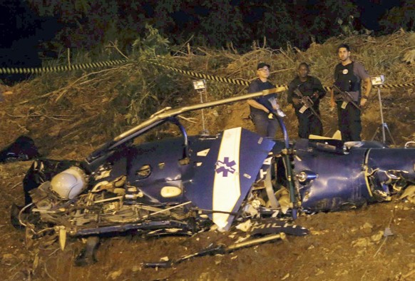 epa05639442 A photograph made available on 20 November 2016 shows emergency workers at the scene of a police helicopter crash over the City of God favela in Rio de Janeiro, Brazil, 19 November 2016. F ...