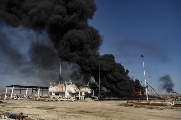 A smoke rises from an oil depot struck by Turkish air force near the town of Qamishli, Syria, Wednesday, Nov. 23, 2022. Turkey's president says he will carry out a land invasion into Kurdish areas of  ...