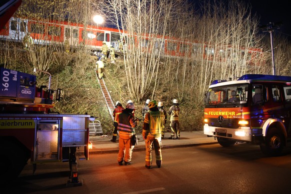 Rettungskräfte arbeiten an der Unfallstelle. Beim Zusammenstoss zweier S-Bahnen im Landkreis München sind am Montag ein Mensch getötet und mehr als zehn verletzt worden.