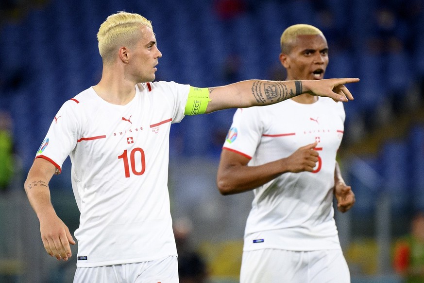 Switzerland&#039;s midfielder Granit Xhaka, left, gestures in front of Switzerland&#039;s defender Manuel Akanji, right, during the Euro 2020 soccer tournament group A match between Italy and Switzerl ...