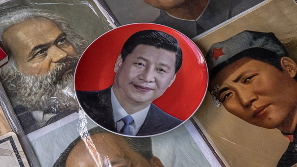 epa09430039 A plate with a picture of Chinese President Xi Jinping lays next to pictures of a former leader Mao Zedong and German philosopher and revolutionary socialist Karl Marx, at the Panjiayuan a ...