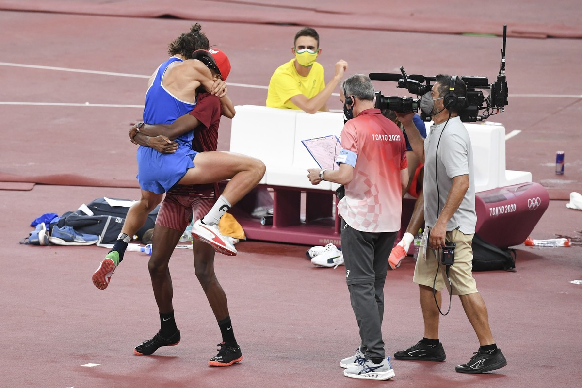 epa09385729 Gianmarco Tamberi of Italy (L) and Mutaz Essa Barshim of Qatar (2-L) celebrate as they share the first place and gold medal in the Men's High Jump Final during the Athletics events of ...