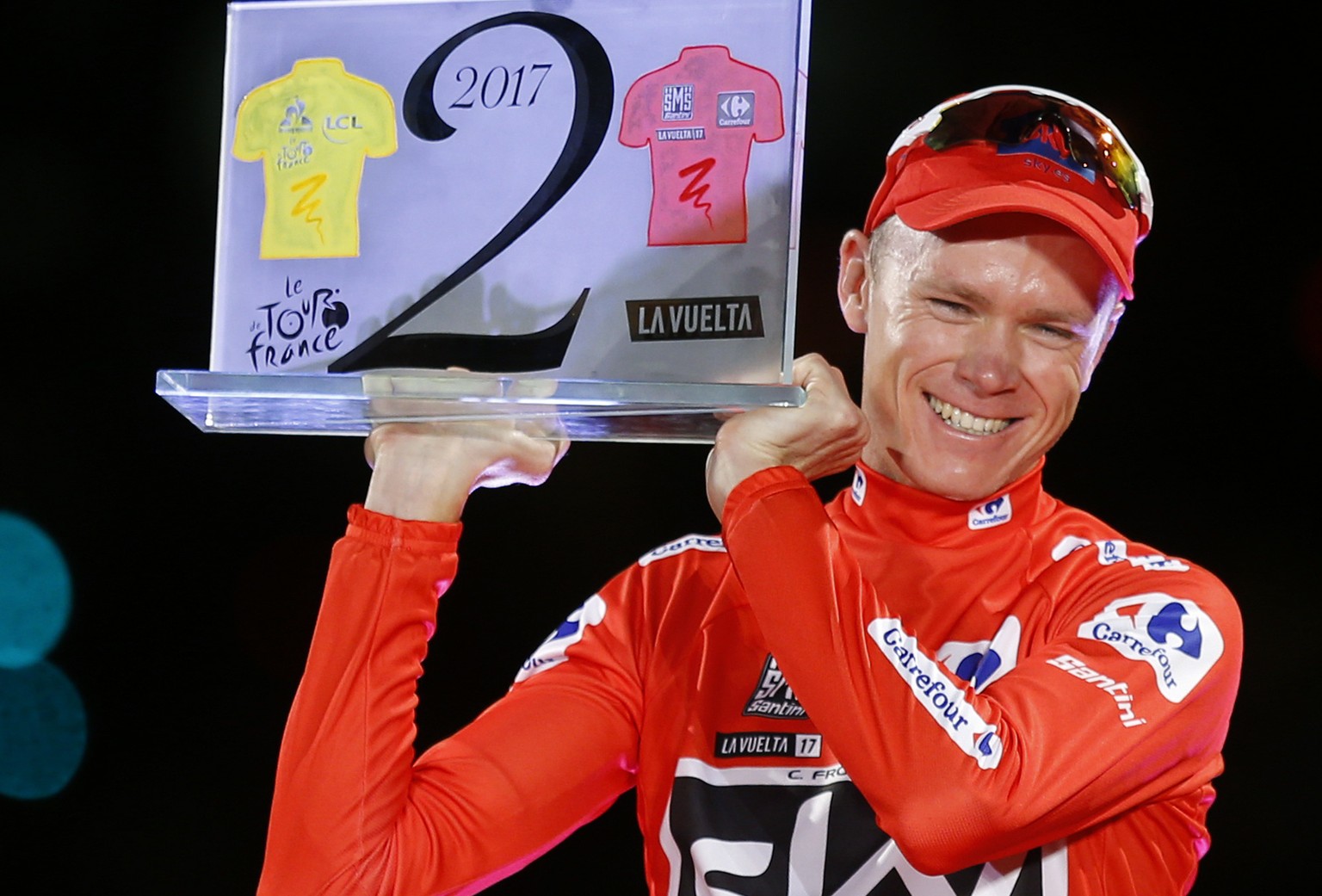 FILE - In this Sunday, Sept. 10, 2017 file photo, Britain&#039;s Chris Froome celebrates on podium after winning the Spanish Vuelta cycling race, in Madrid. The special trophy he holds was given to hi ...