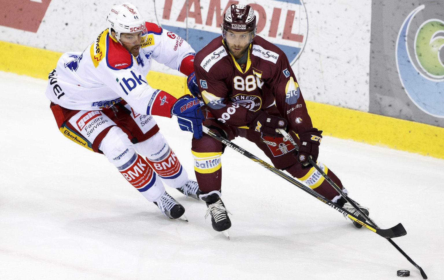 Kloten&#039;s forward Matthias Bieber, left, vies for the puck with Geneve-Servette&#039;s center Kevin Romy, right, during the overtime of the game of National League A (NLA) Swiss Championship betwe ...