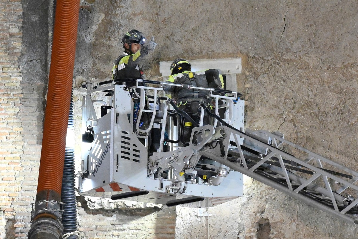 A firefighter gives a thumbs-up as rescuers pull a construction worker from under the debris of a medieval tower that was under renovation near the Roman Forum in Rome, Monday, Nov. 3, 2025, after it  ...
