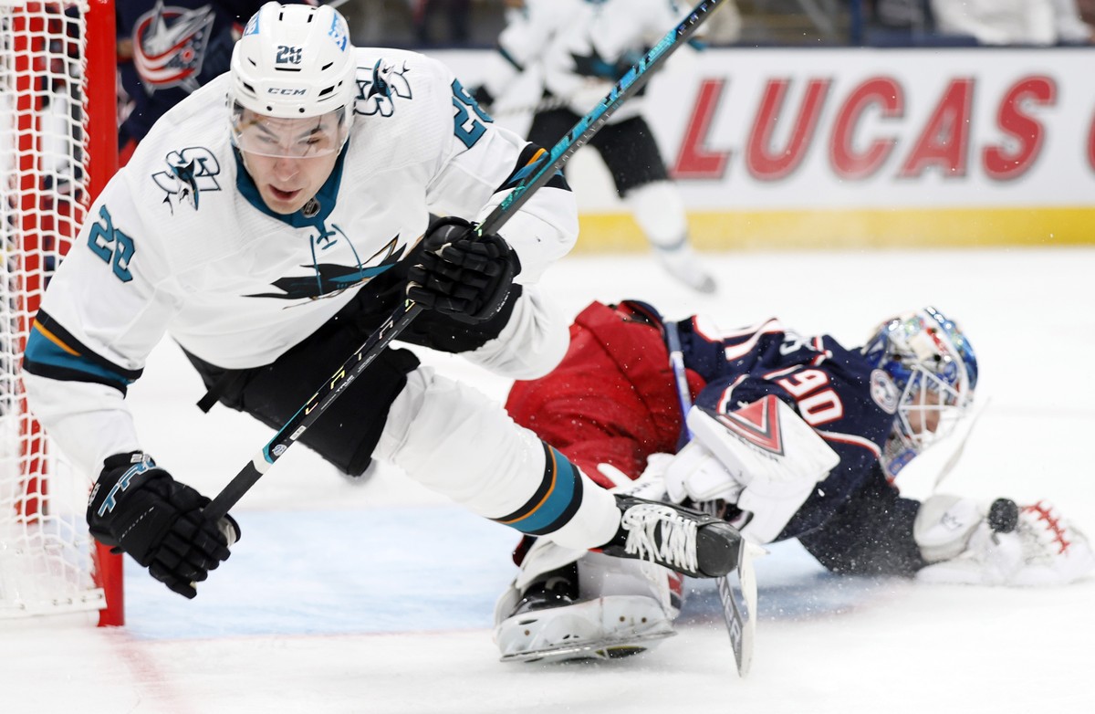 Columbus Blue Jackets' Elvis Merzlikins, right, makes a save as San Jose Sharks' Timo Meier trips during the first period of an NHL hockey game Sunday, Dec. 5, 2021, in Columbus, Ohio. (AP P ...