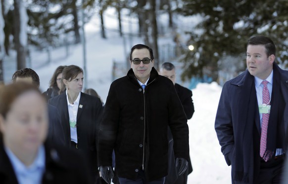 Steven Mnuchin, United States Secretary of the Treasury, walks through the snow during the annual meeting of the World Economic Forum in Davos, Switzerland, Wednesday, Jan. 24, 2018. (AP Photo/Markus Schreiber)
