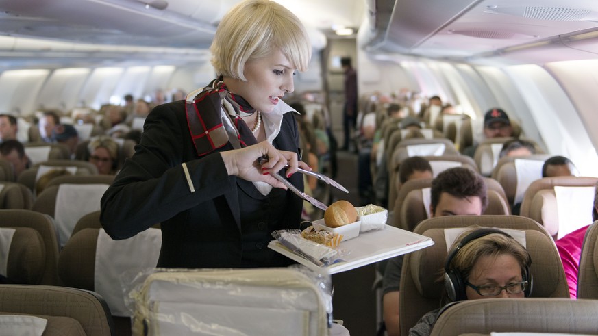 ARCHIVBILD ZUM IMPFOBLIGATORIUM BEI BESATZUNGEN BEI SWISS --- Eine Flugbegleiterin bedient die Passagiere der Economy Class, aufgenommen am 29. April 2013 in einem Flugzeug der Swiss. Die Schweizer Fl ...