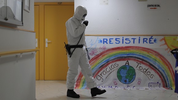 A member of the UME (Emergency Army Unit) wearing a wearing a protective suit to protect against coronavirus disinfects next to a banner reading in Spanish: &quot;I will resist, Thanks everybody&quot; at a nursing home in Madrid, Spain, Tuesday, March 31, 2020. The new coronavirus causes mild or moderate symptoms for most people, but for some, especially older adults and people with existing health problems, it can cause more severe illness or death. (AP Photo/Manu Fernandez)