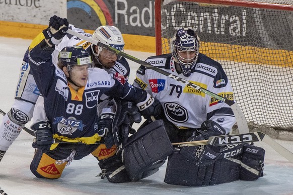 Sven Senteler, links, von Zug im Spiel gegen Samuel Guerra, mitte, und Torhter Daniel Manzato, rechts, von Ambri beim Eishockey Meisterschaftsspiel in der Qualifikation der National League zwischen d ...