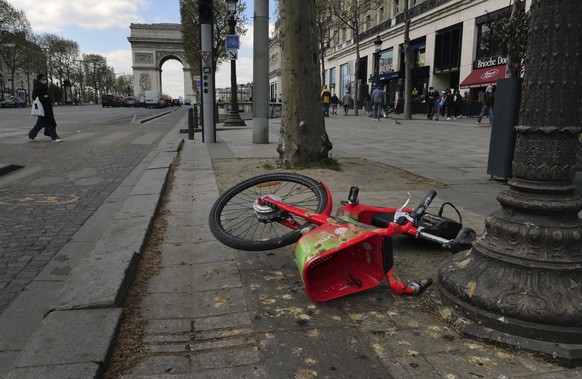A rental bicycle is overturned on the Champs Elysee avenue in Paris, Thursday, April 8, 2021. Paris, the City of Light is being trolled online as the city of trash, after social media users have flood ...