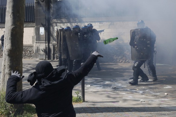 A hooded youth throws a bottle during a clash with French riot police to protest against the French labour law proposal during the May Day labour union march in Paris, France, May 1, 2016. REUTERS/Phi ...