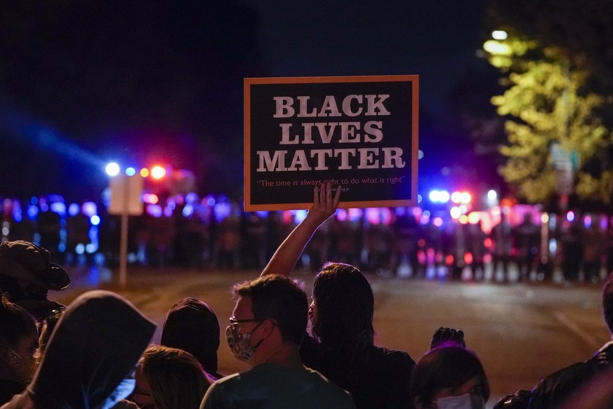 Protesters and police line up Friday, Oct. 9, 2020, in Wauwatosa, Wis. On Wednesday, District Attorney John Chisholm refused to issue charges against Wauwatosa Police Officer Joseph Mensah for the Feb ...