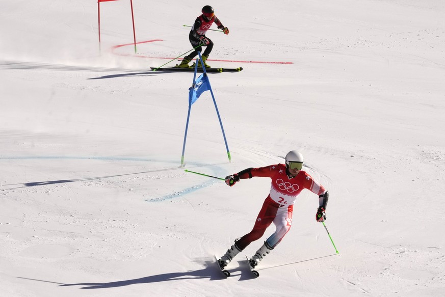 Gino Caviezel of Switzerland leads Zhang Yangming of China during the mixed team parallel skiing event at the 2022 Winter Olympics, Sunday, Feb. 20, 2022, in the Yanqing district of Beijing. (AP Photo ...