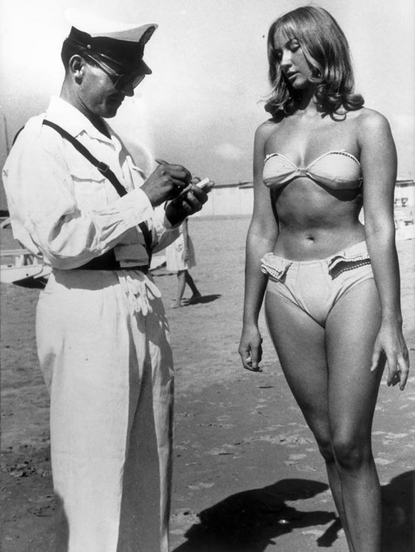 Ein italienischer Polizist gibt einer Frau einen Strafzettel, weil sie verbotenerweise einen Bikini trägt, 1950er.