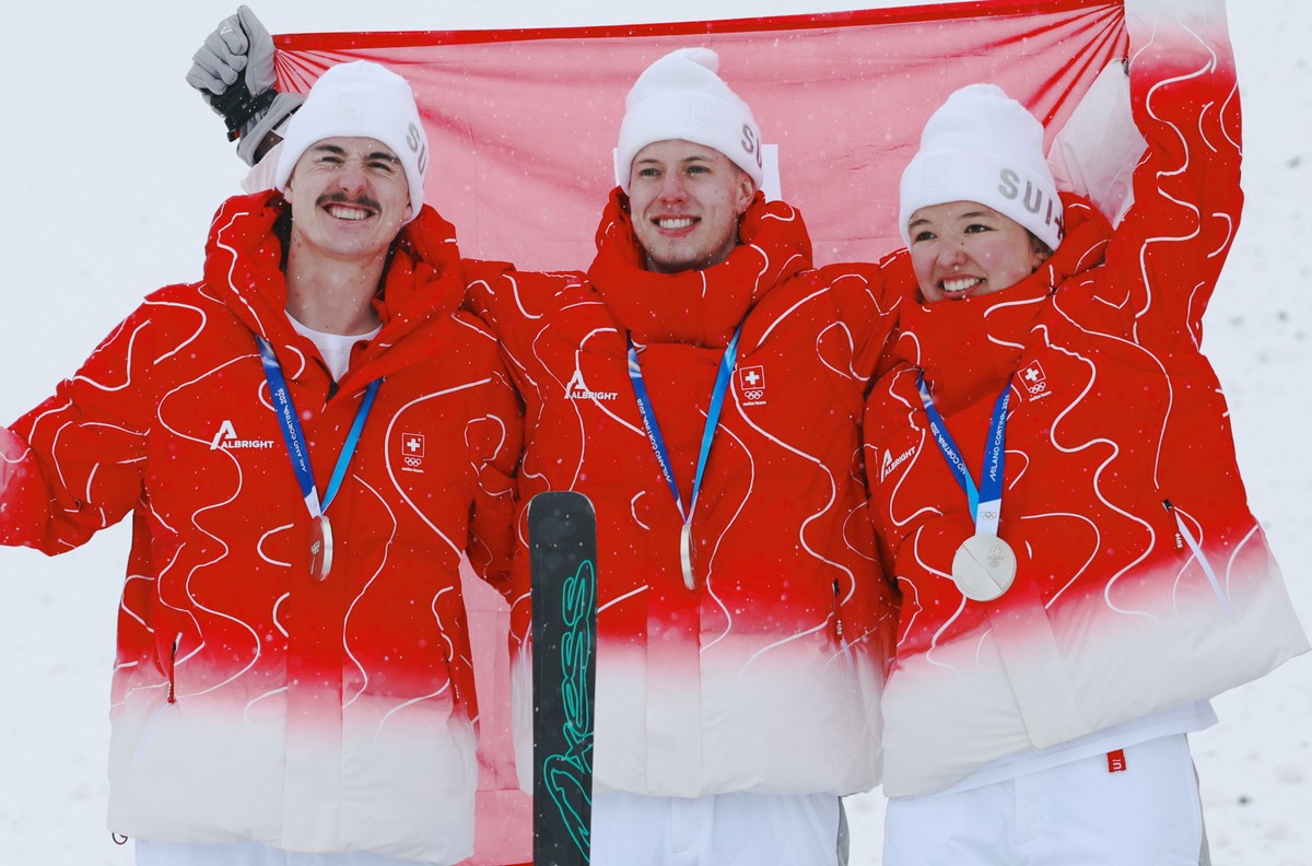 epa12764520 (L-R) Silver medalists Noe Roth, Pirmin Werner, and Lina Kozomara of Team Switzerland celebrate after the Mixed Team Aerials Finals of the Freestyle Skiing competitions at the Milano Corti ...