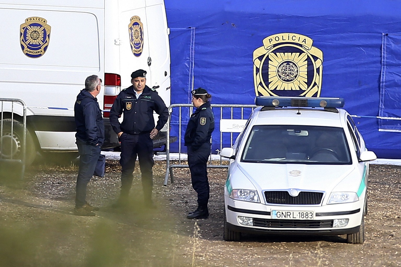 Police officers talk at an operation tent near Barragem do Arade, Portugal, Tuesday, May 23, 2023. Portuguese police said they are continuing the search for Madeleine McCann, the British toddler who disappears…