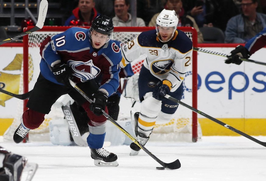 Colorado Avalanche right wing Sven Andrighetto, front, of Switzerland, picks up a loose puck in front of Buffalo Sabres right wing Jason Pominville in the first period of an NHL hockey game Tuesday, D ...