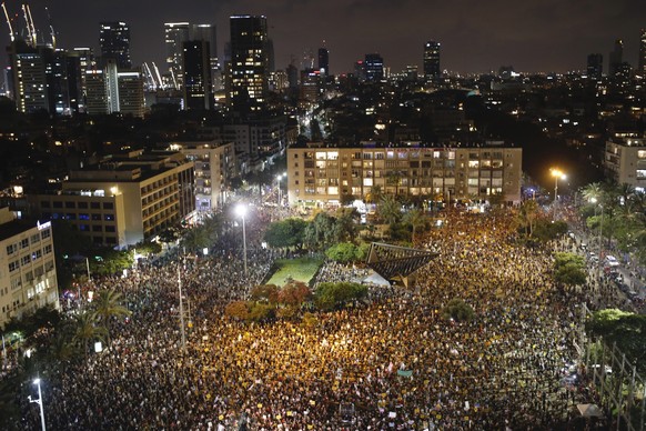 Protesters hold signs during a demonstration against Israel&#039;s government in Rabin square in Tel Aviv, Israel, Saturday, July 11, 2020. Thousands of Israelis gathered Saturday to protest the new g ...