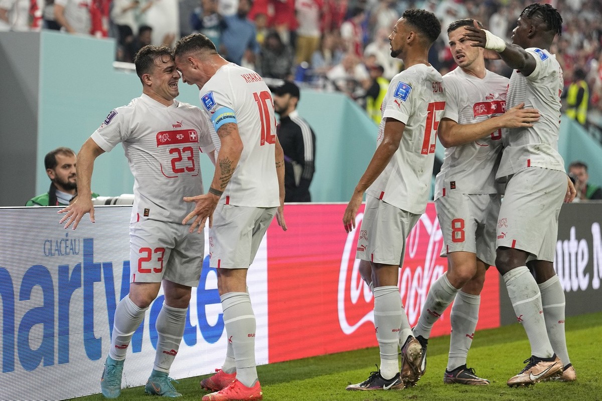 Switzerland's Xherdan Shaqiri, left, celebrates with teammates after scoring his side's opening goal during the World Cup group G soccer match between Serbia and Switzerland, at the Stadium  ...