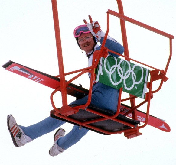 IMAGO / Sven Simon

Michael Edwards (Großbritannien) alias Eddie the Eagle grüßt mit dem Peace-Zeichen aus einem Sessellift / Der erste Brite, bei einem olympischen Skispringen war mehr Publikumsliebl ...