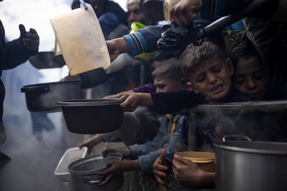 FILE - Palestinians line up for a meal in Rafah, Gaza Strip, Friday, Feb. 16, 2024. According to the Global Report on Food Crises released Wednesday, April 24, nearly 282 million people in 59 countrie ...