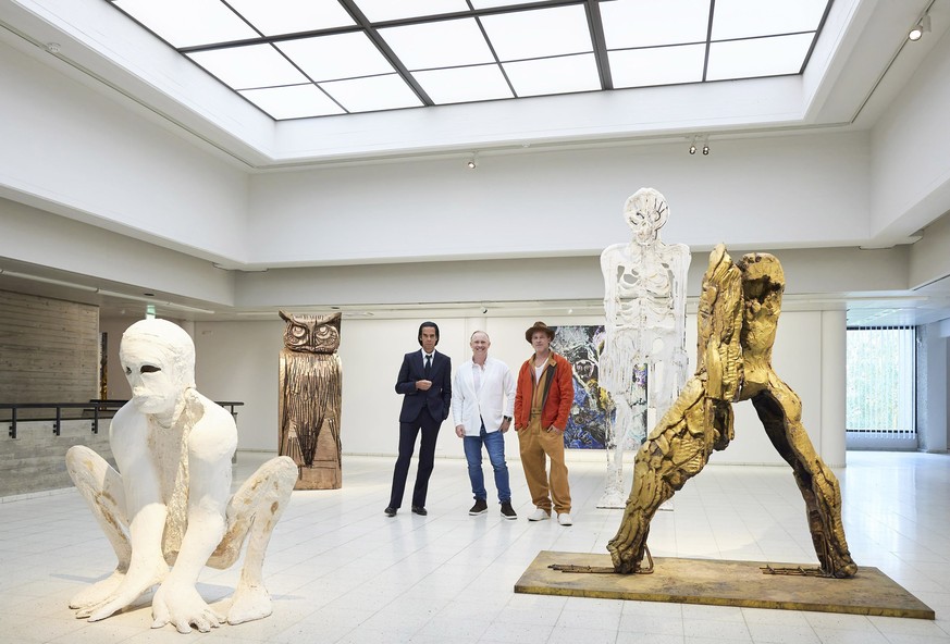 In this photo provided by Sara Hilden Art Museum, British artist Thomas Houseago, centre, poses with US actor Brad Pitt, centre right and Australian musician Nick Cave, prior to the opening of their j ...