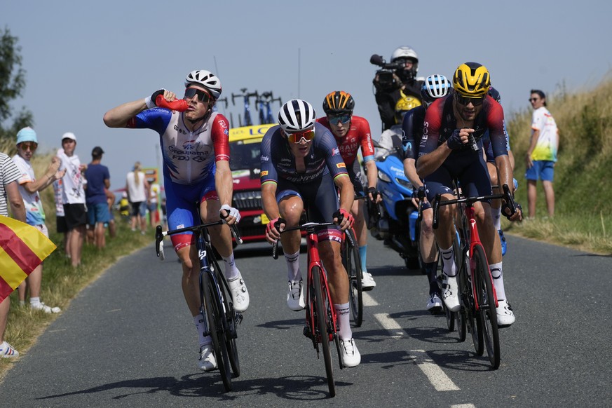 Switzerland&#039;s Stefan Kueng drinks as Denmark&#039;s Mads Pedersen, second left, Britain&#039;s Fred Wright, center rear, and Italy&#039;s Filippo Ganna, right, ride in the breakaway group during  ...