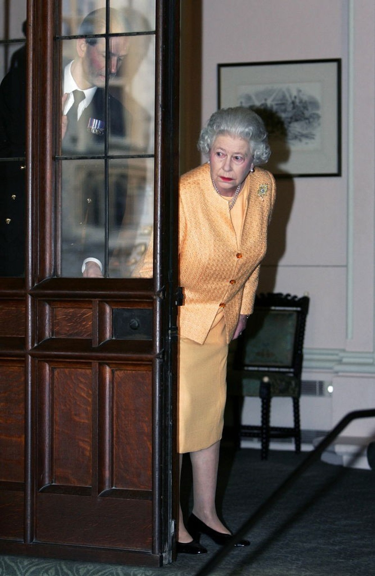 WINDSOR, UNITED KINGDOM - NOVEMBER 19: Queen Elizabeth II and her aide, Paul Whybrew (L), Peer Around A Door To Check The Limousine Awaiting For French President Jacques Chirac And His Wife As They De ...