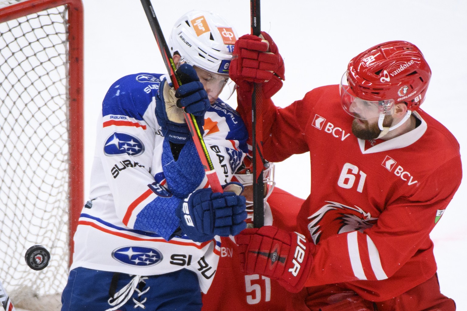 L&#039;attaquant zuerichois Raphael Prassl, gauche, lutte pour le puck avec le defenseur lausannois Fabian Heldner, droite, lors du 1er match de quart de finale playoff a huis clos du championnat suis ...