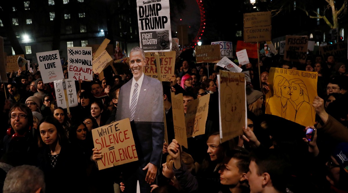 Demonstrators hold placards and an image of former U.S. President Barack Obama during a protest against U.S. President Donald Trump's executive order travel ban in London, Britain January 30, 201 ...