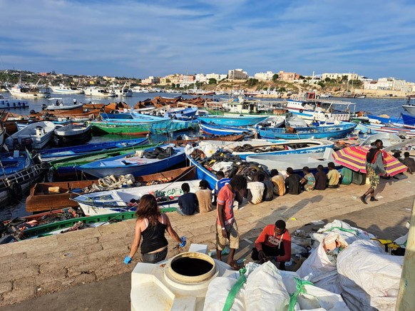 epa10858985 A group of migrants wait on the island of Lampedusa as Italian authorities prepare for transferring people following new arrivals, Italy, 13 September 2023. More than 6,790 migrants were o ...