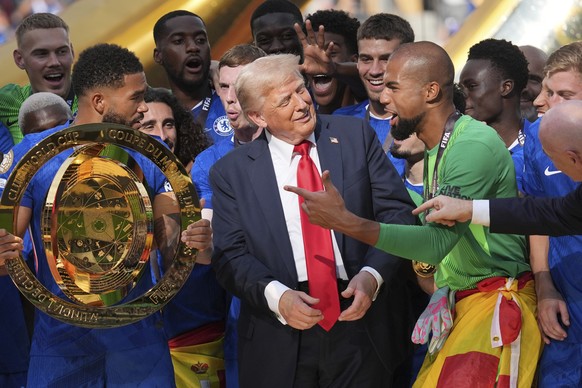 KEYPIX - President Donald Trump, center, speaks with Chelsea&#039;s goalkeeper Robert Sanchez, right, as Chelsea&#039;s Reece James (24) holds the championship trophy following the Club World Cup fina ...