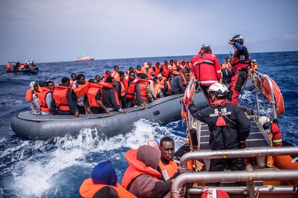 epa07080425 Refugees on a rubber dinghy are rescued by members of the NGO &#039;SOS Mediterranee&#039; from the &#039;Aquarius&#039; vessel during an operation to rescue migrants, about 50 kilometers  ...